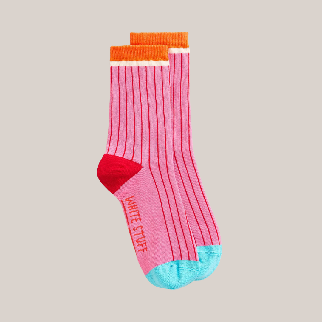 Pink socks with orange and blue accents on a beige background