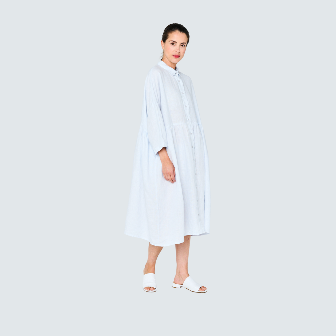 Light blue linen shirt dress, midi length, collared, three-quarter sleeves.