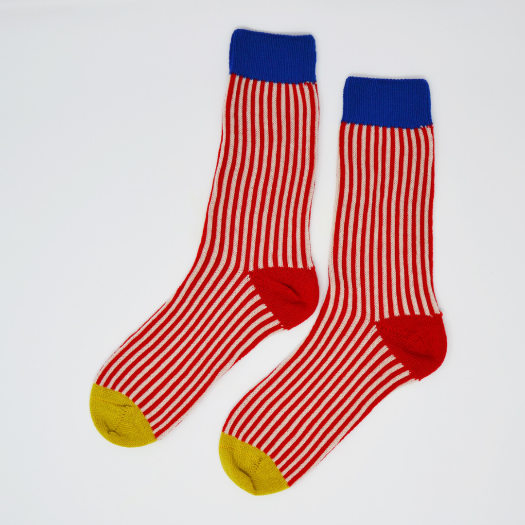 Pair of red and cream striped socks with blue cuffs and yellow toes.
