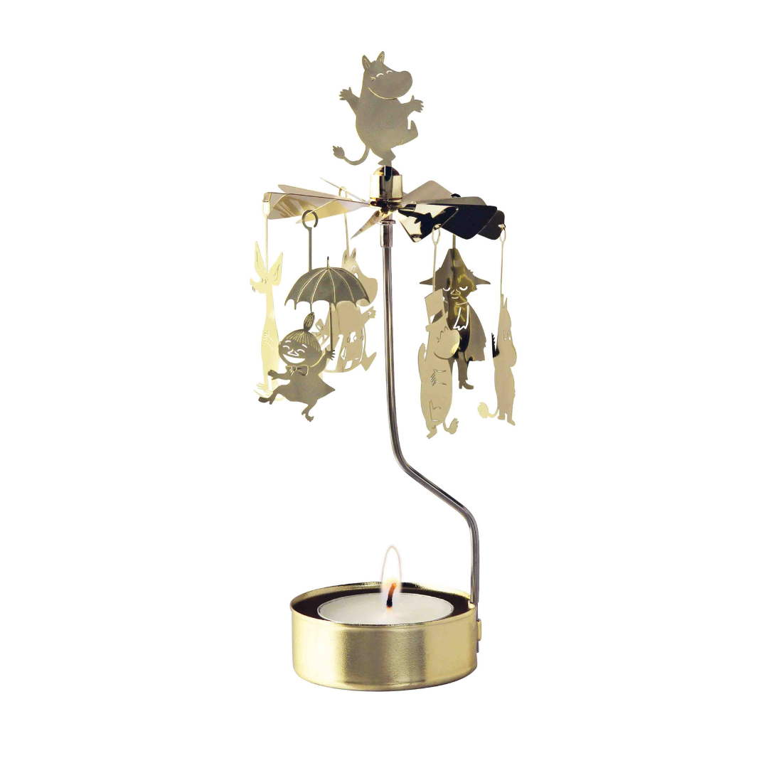 Gold Moomin character candleholder with rotating figures and a lit tea light.