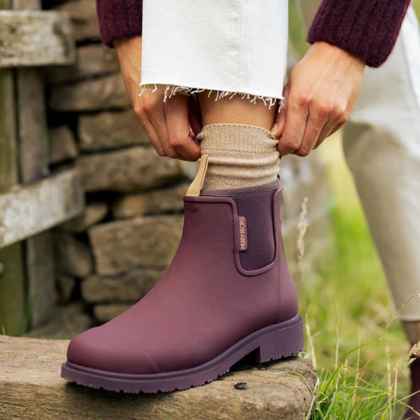 Burgundy rubber ankle boots with a low block heel.  The boots have a subtle brand label on the side.