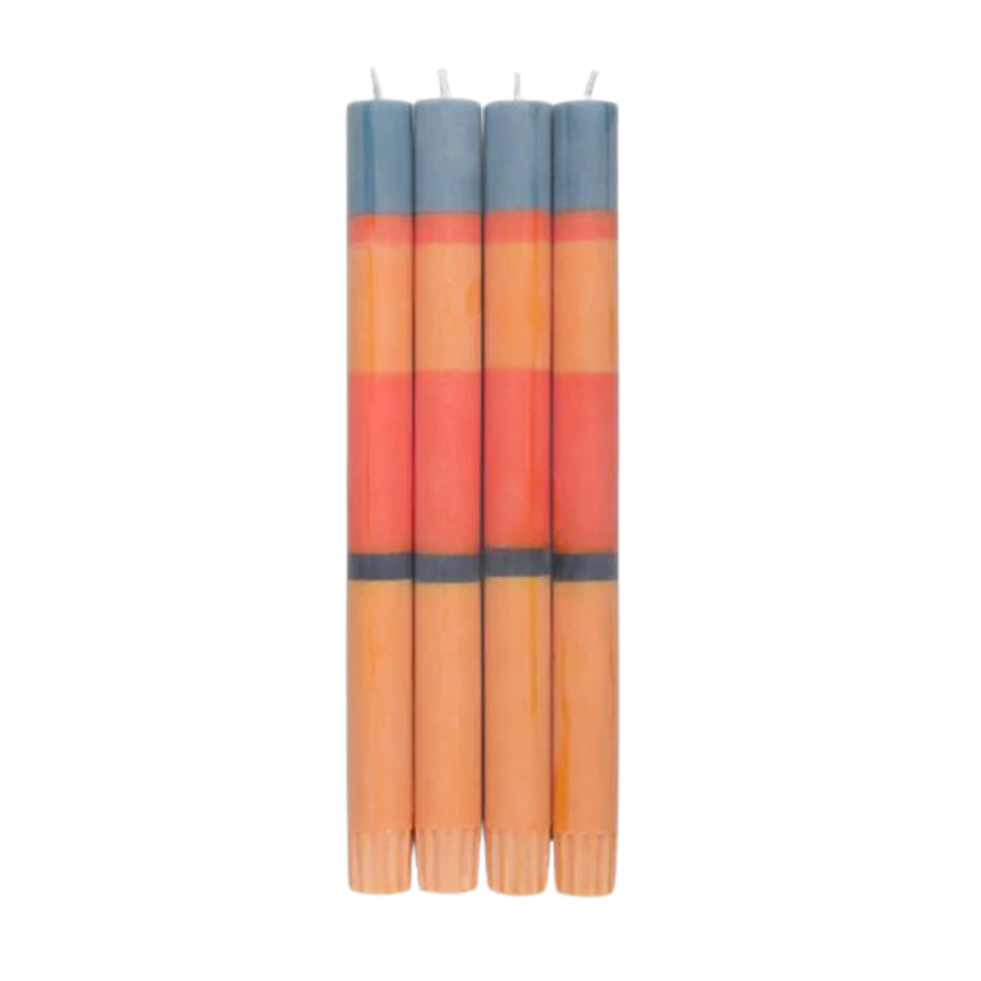 Four striped candles in shades of orange, peach, and gray.