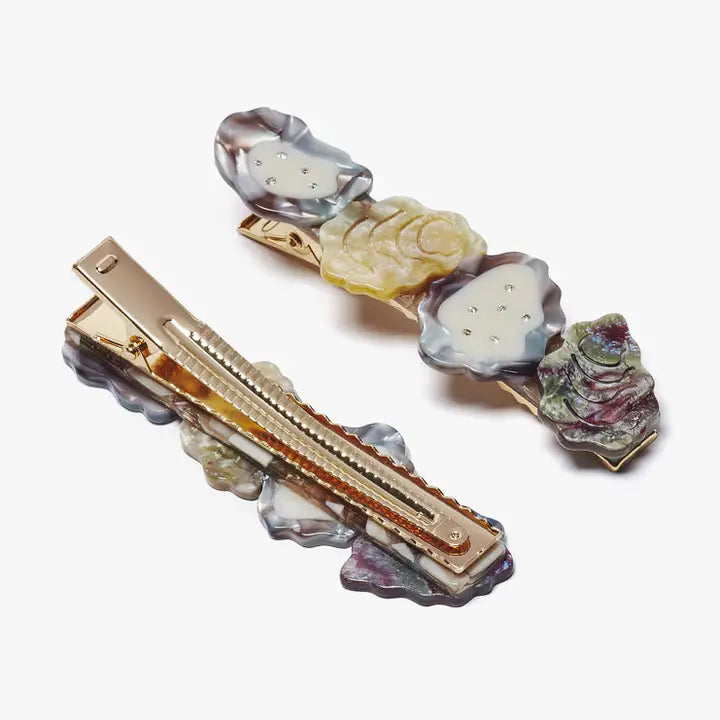Decorative hair barrette with multicolored stones on a white background