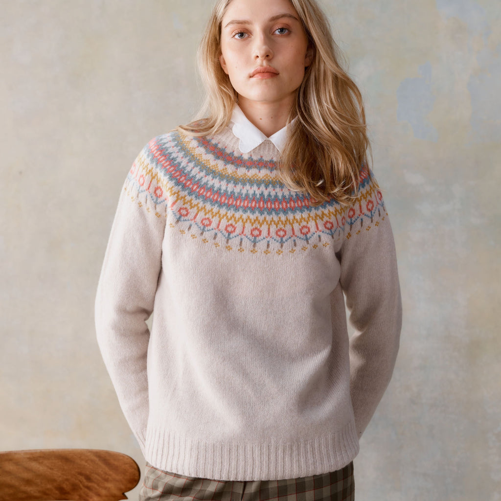Cream-colored wool sweater with a colorful Fair Isle yoke featuring geometric patterns in muted blues, pinks, and golds.