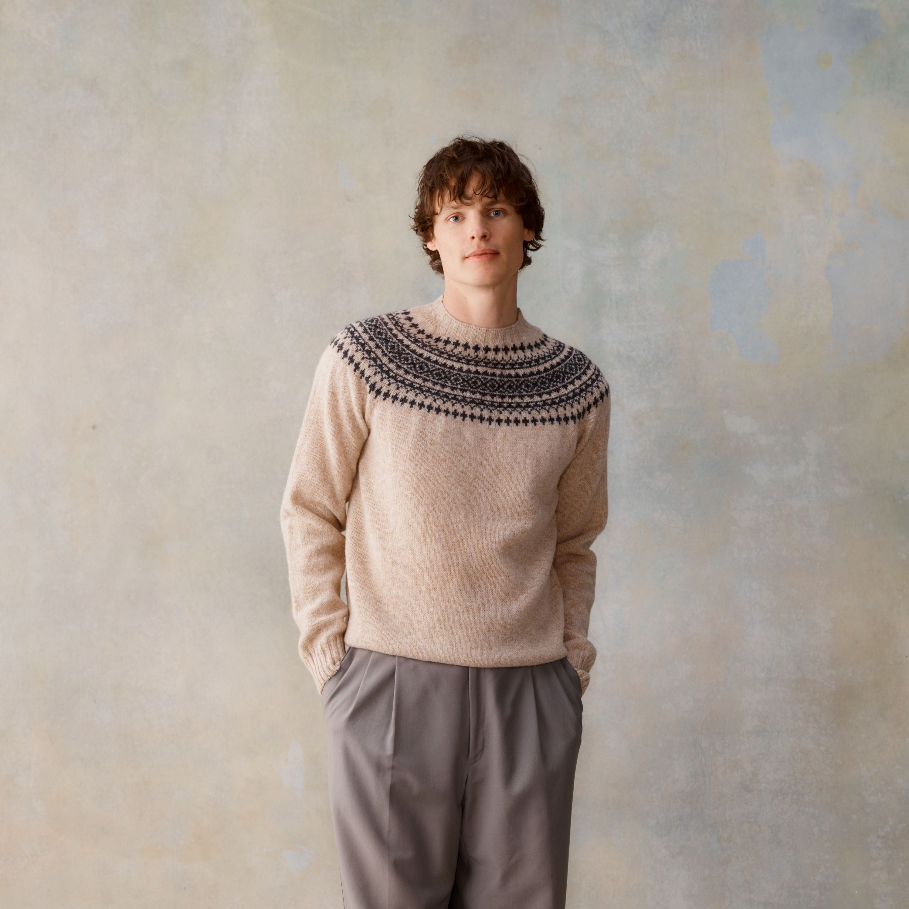 Beige crewneck sweater with dark-colored Nordic-style pattern at neckline.