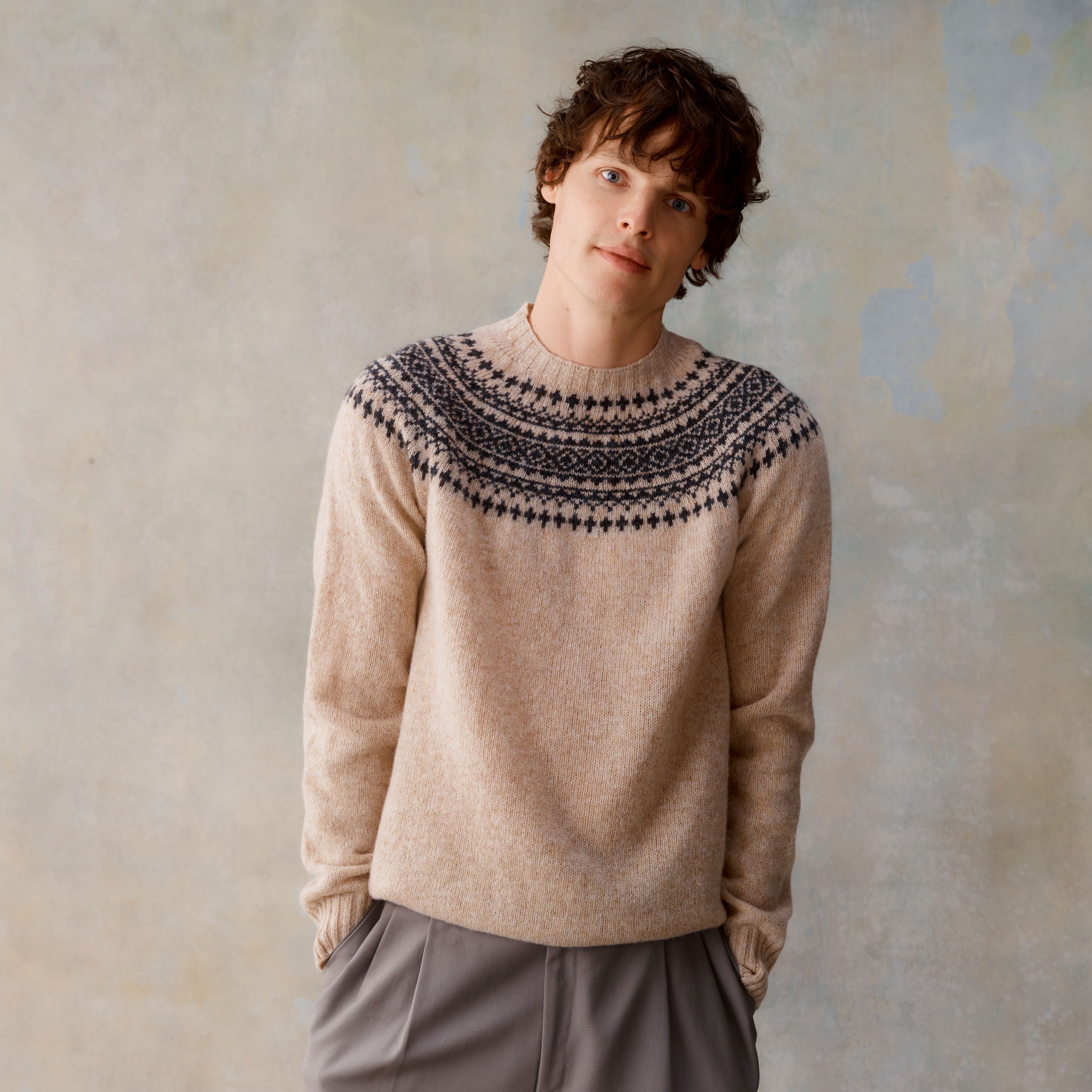 Beige crewneck sweater with a dark-colored Fair Isle yoke pattern.