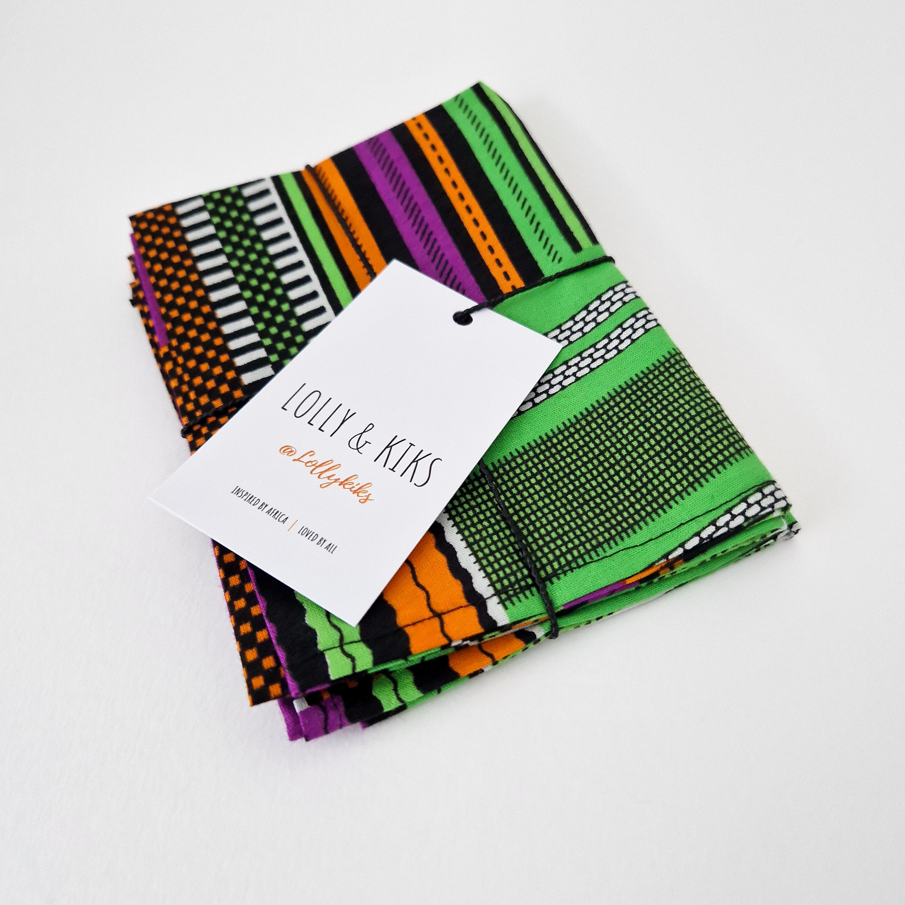 Stack of colorful striped fabric napkins tied with twine and a Lolly & Kiks brand tag.