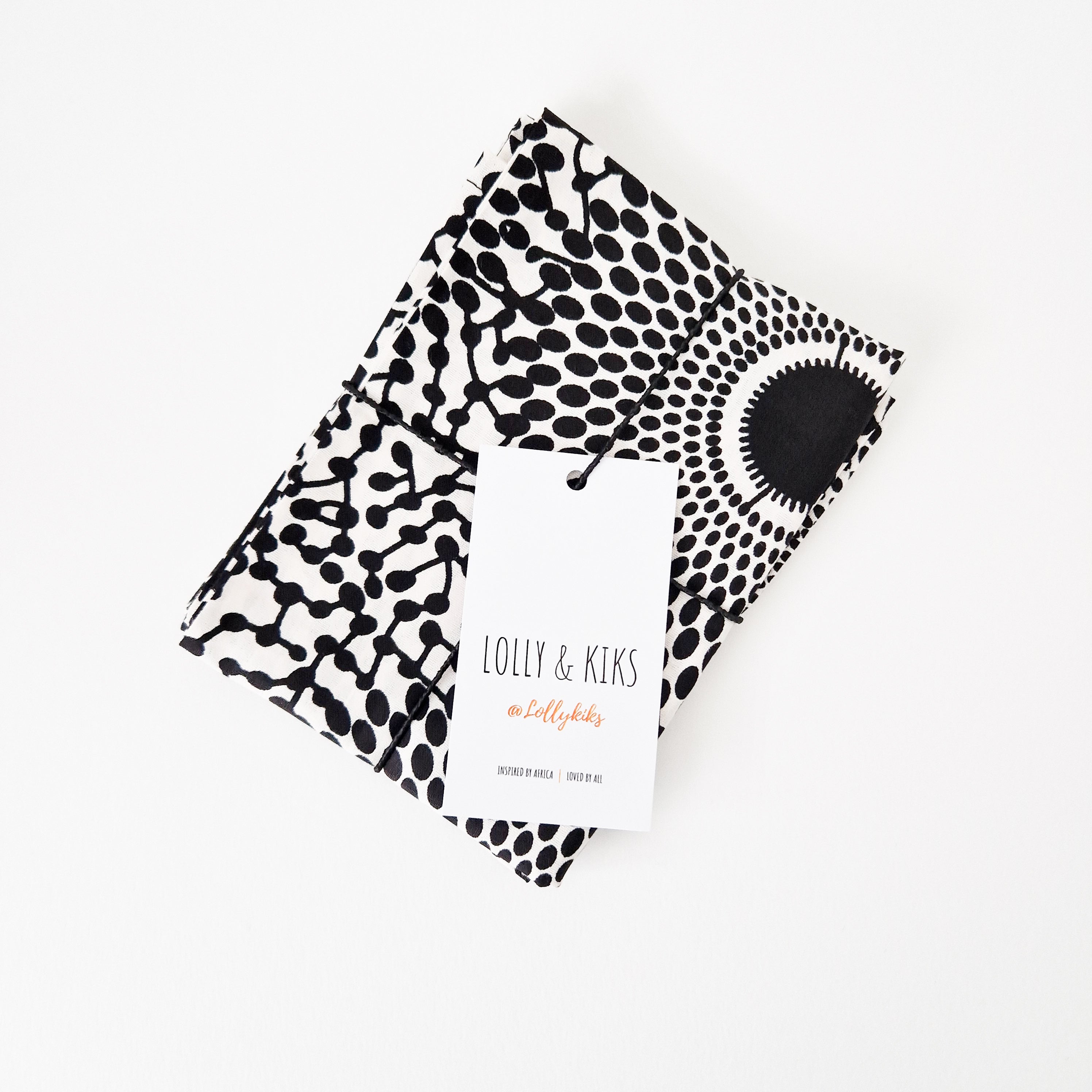 Folded black and white patterned fabric with a brand tag reading "Lolly & Kiks".