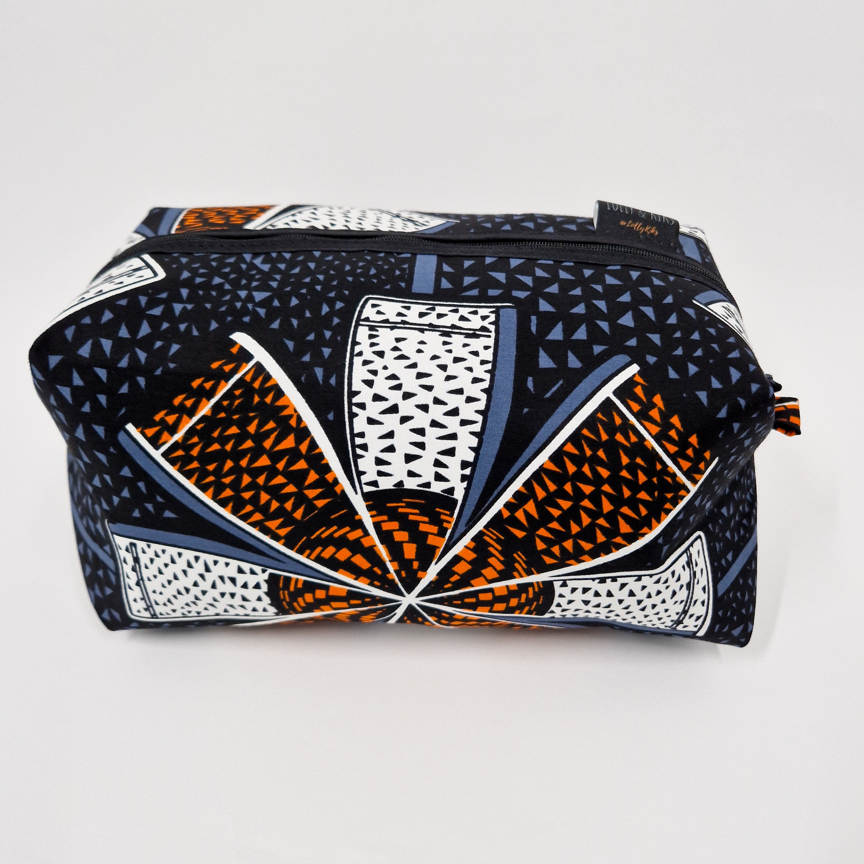 Rectangular zippered cosmetic bag with a black background and a geometric pattern in orange, white, and blue.