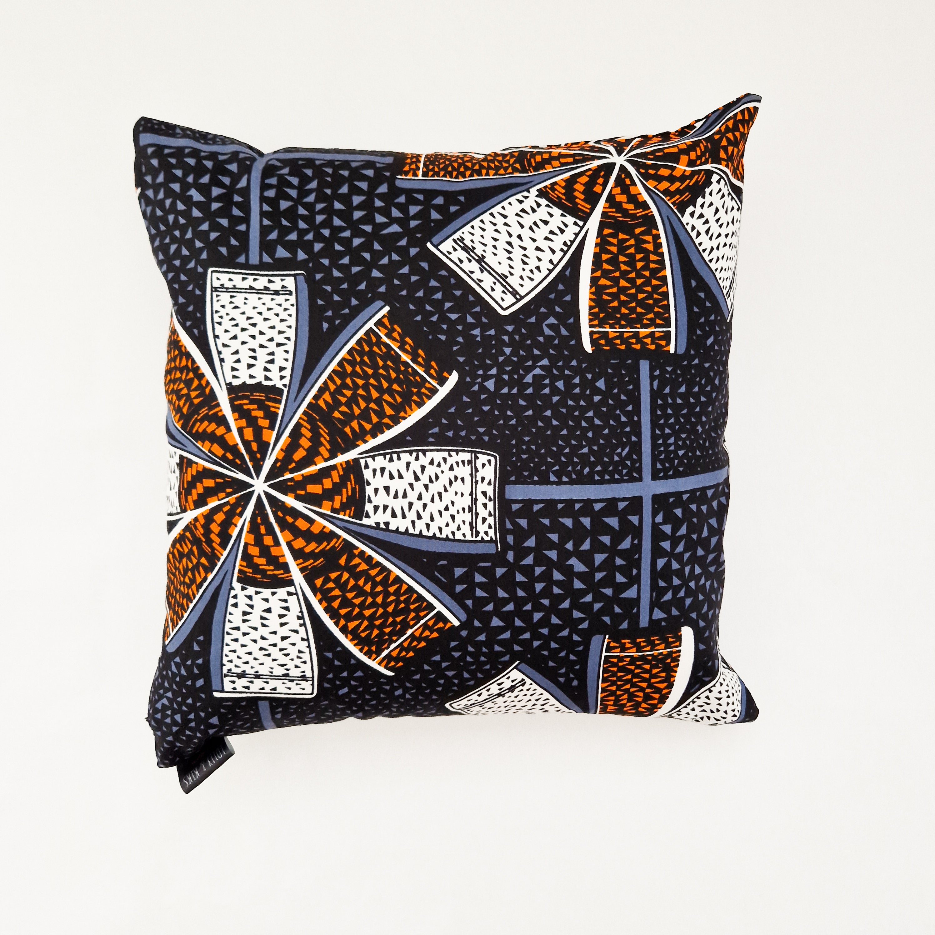 Square cushion with a bold geometric pattern in orange, blue, white, and black.