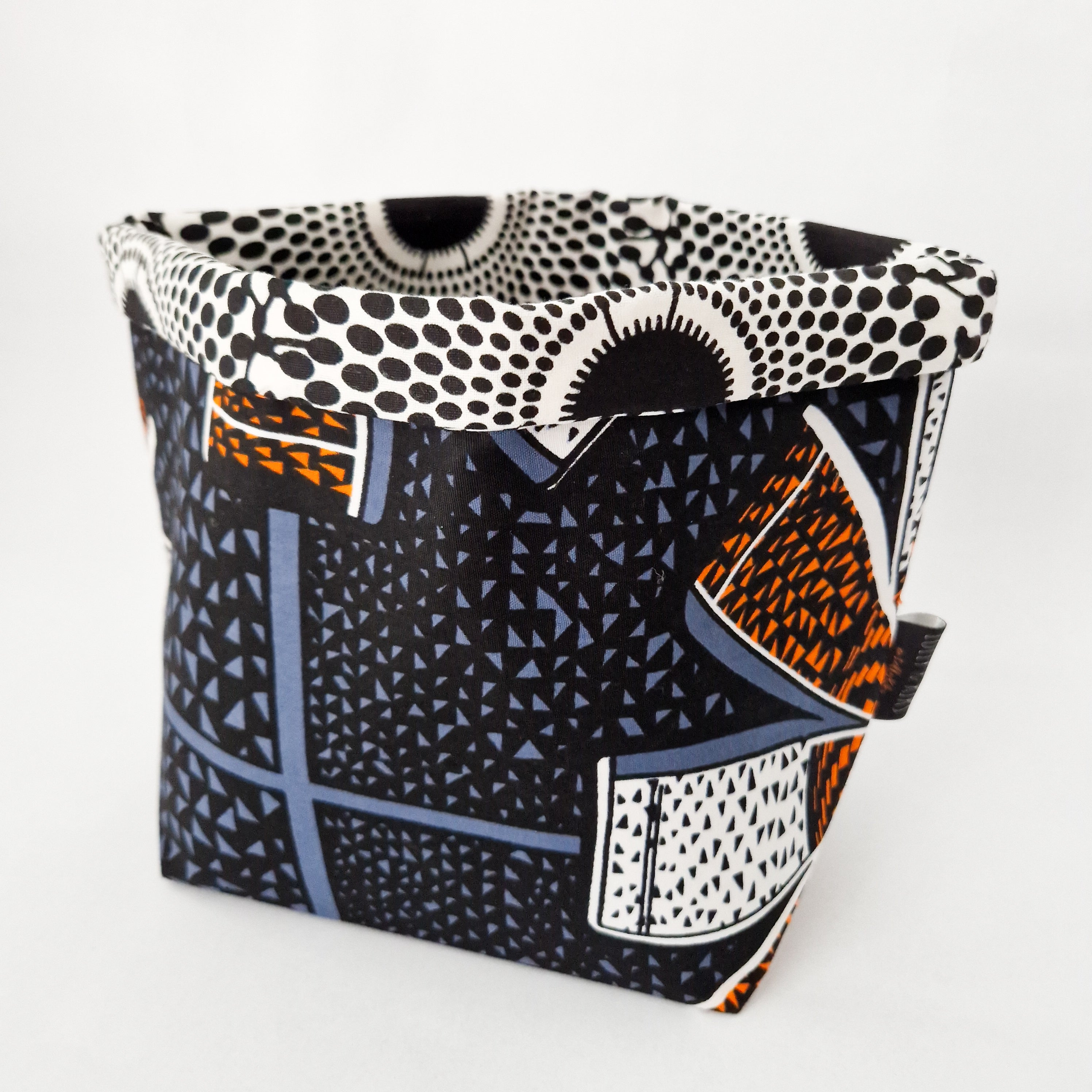 Fabric storage bin with black, orange, and blue geometric and polka dot pattern.