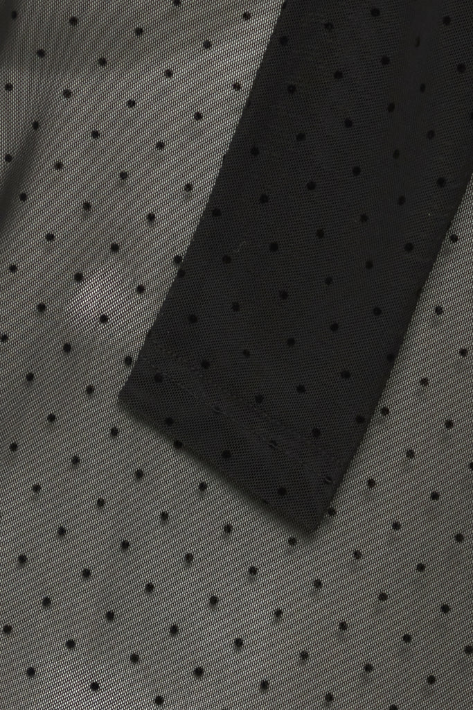 Fransa garment featuring a dark green sheer fabric with black polka dots and black trim.
