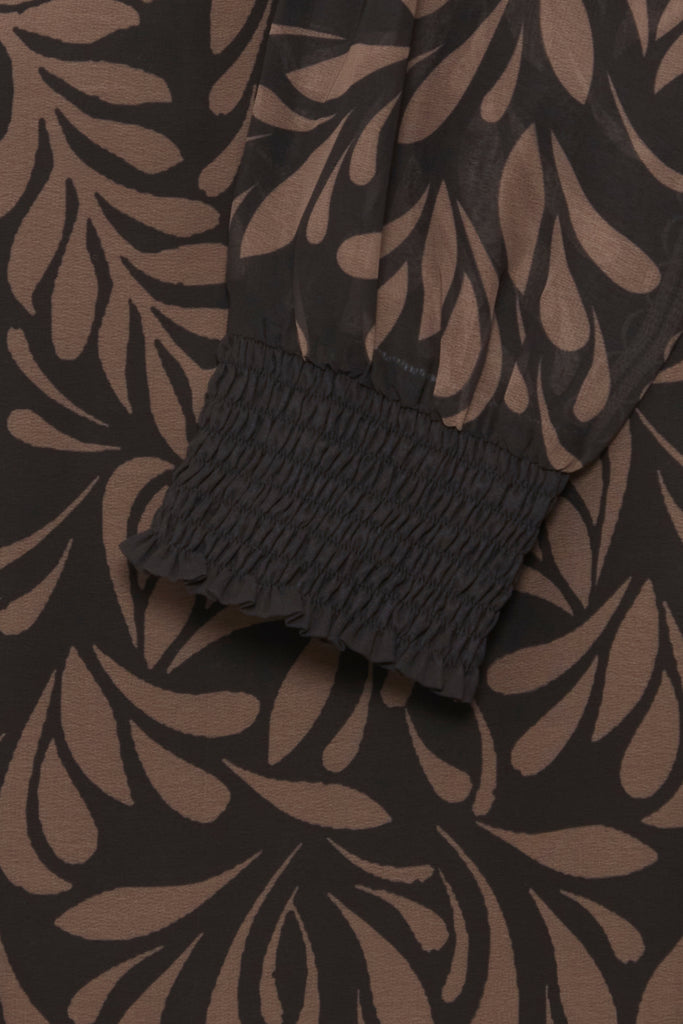 Close-up of a Fransa blouse featuring black and brown floral patterns with a smocked black sleeve cuff.