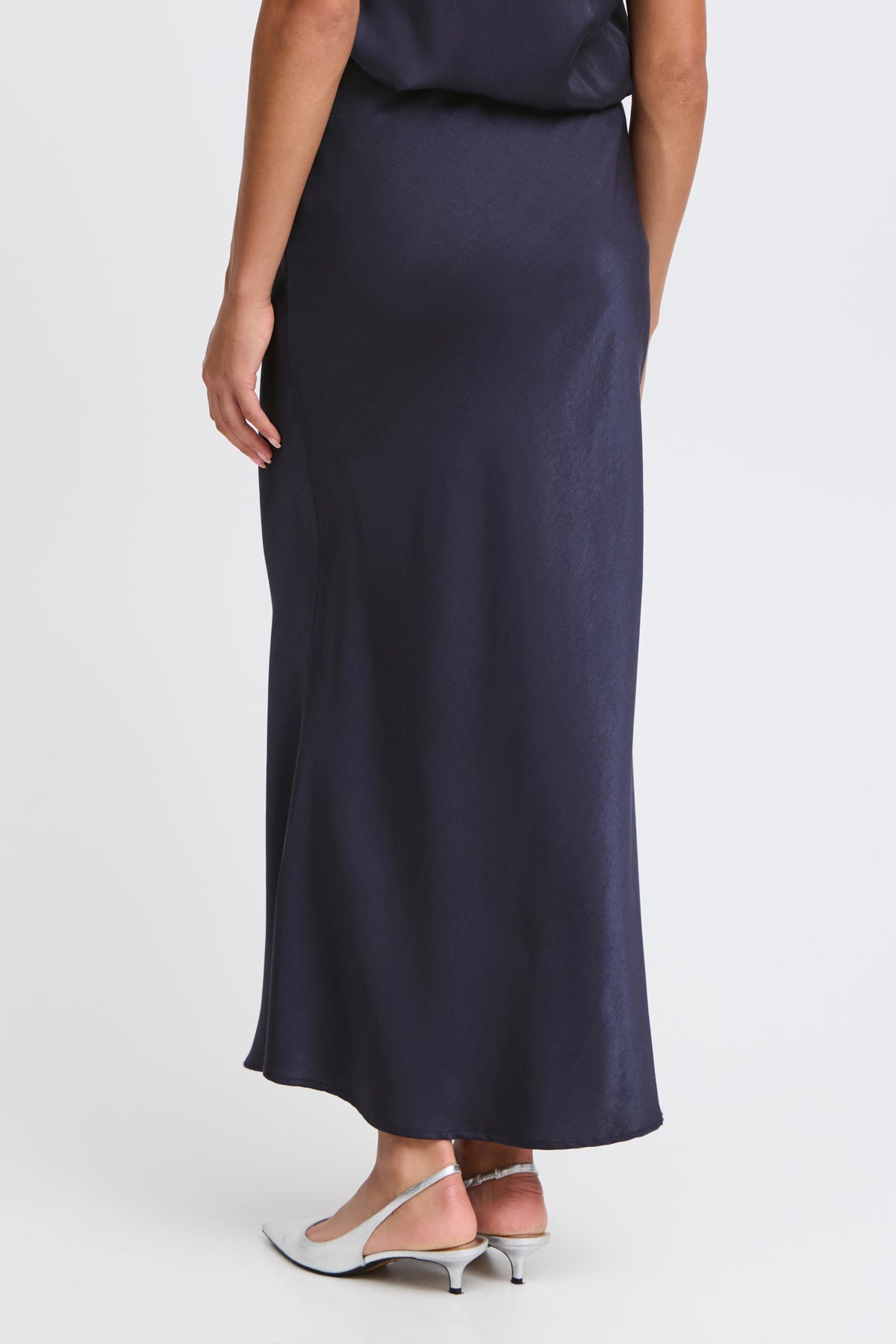 Dark navy blue bias-cut maxi skirt in a lustrous satin fabric.  The skirt has a flowing, slightly asymmetrical hemline.