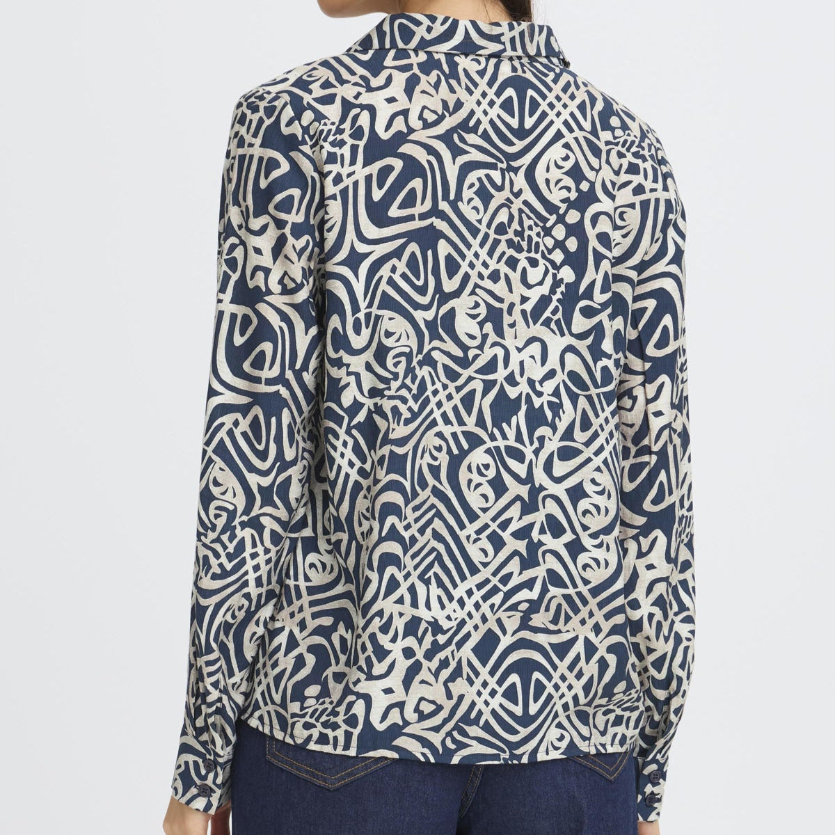 Woman wearing a blue and white patterned shirt on a white background