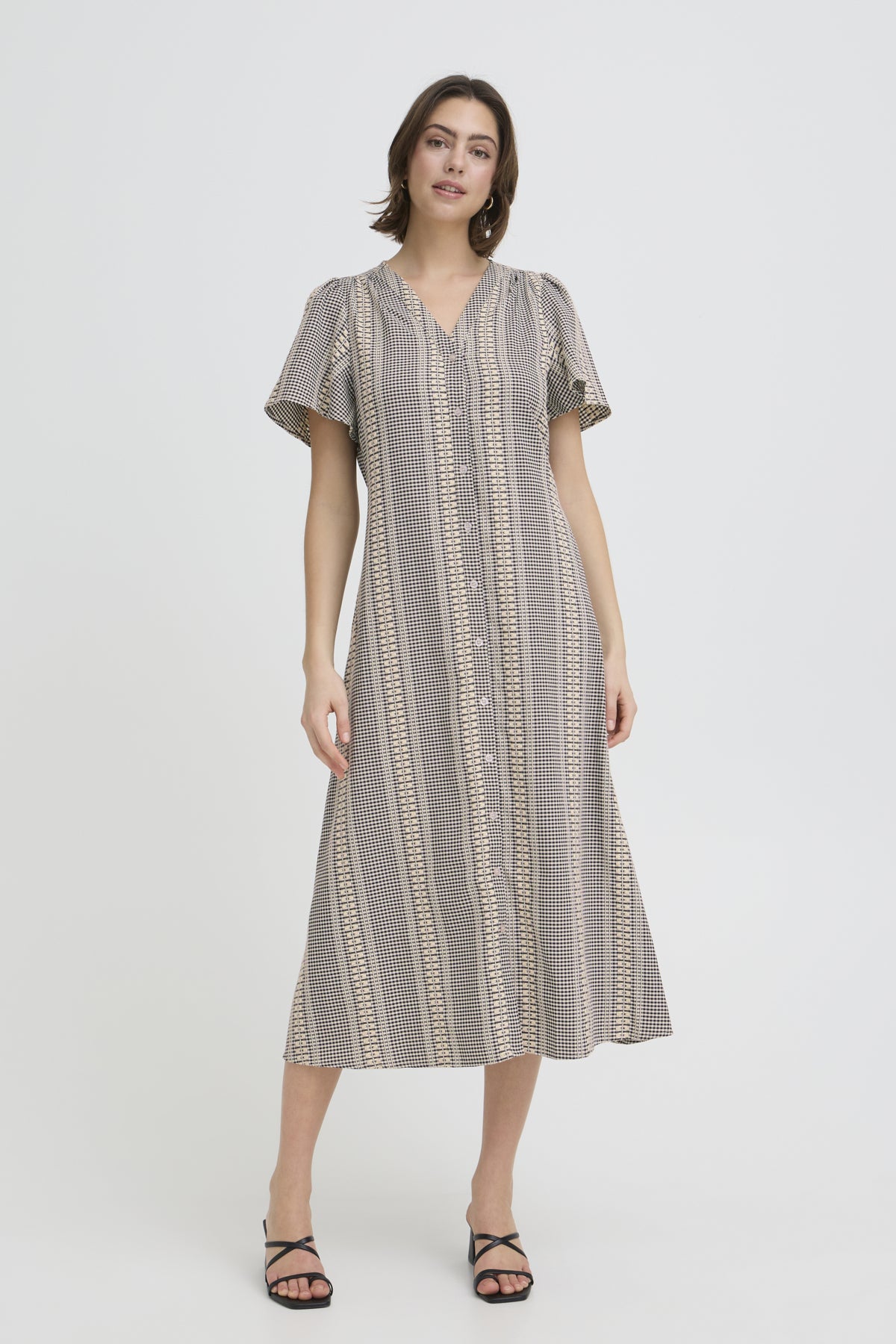 Woman wearing a patterned dress on a white background