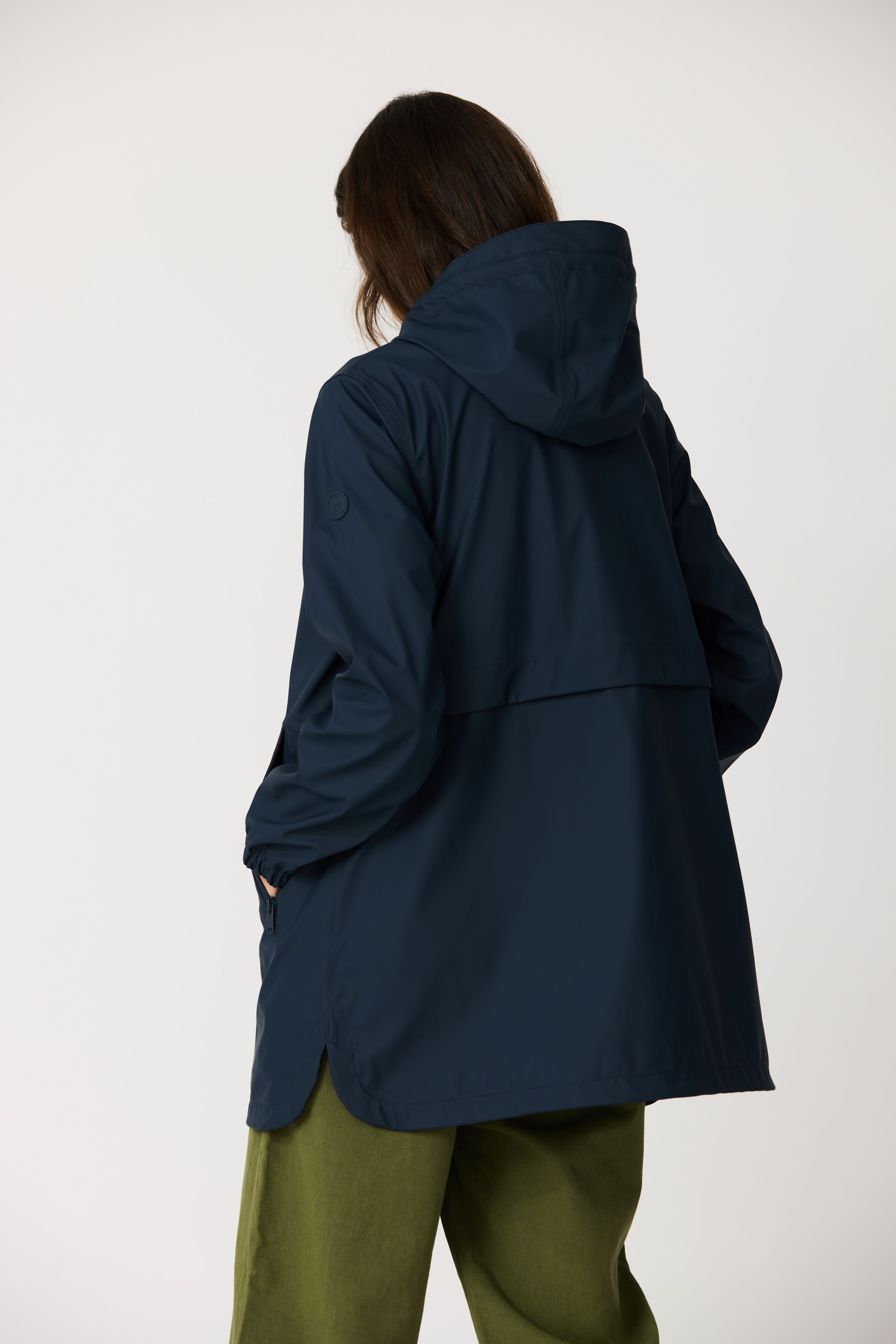 Person wearing a navy blue hooded jacket on a white background