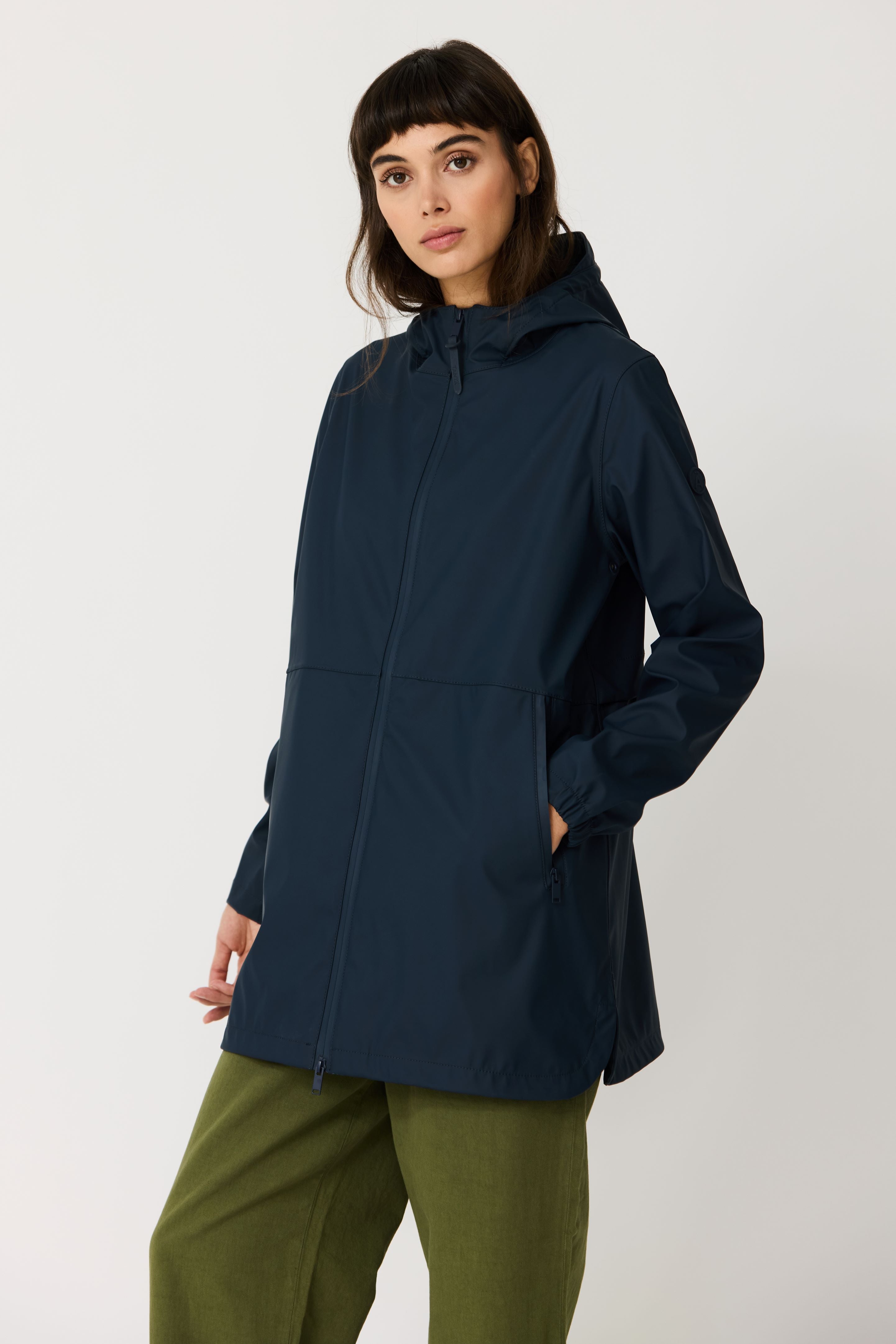 Woman wearing a navy blue hooded jacket on a white background