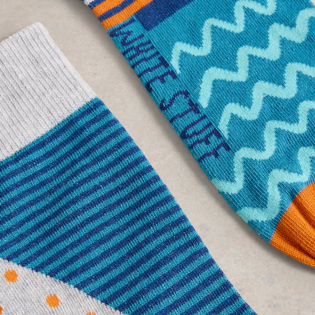 Pair of teal and gray striped crew socks with geometric patterns and orange accents.