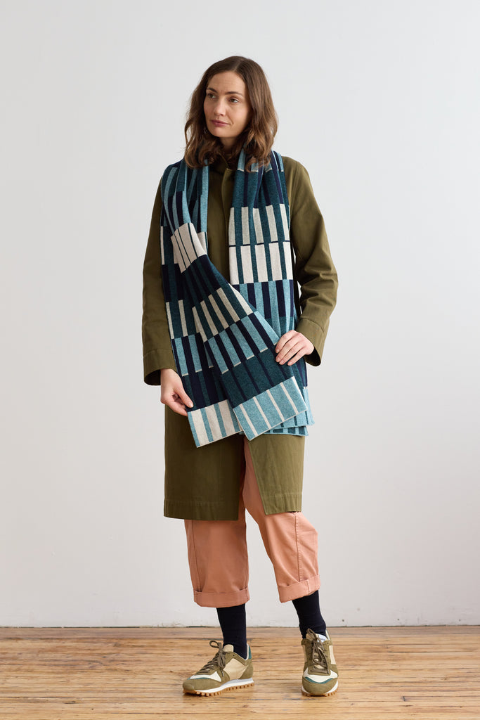 Woven wool scarf with a geometric pattern of teal, navy, and cream vertical stripes.