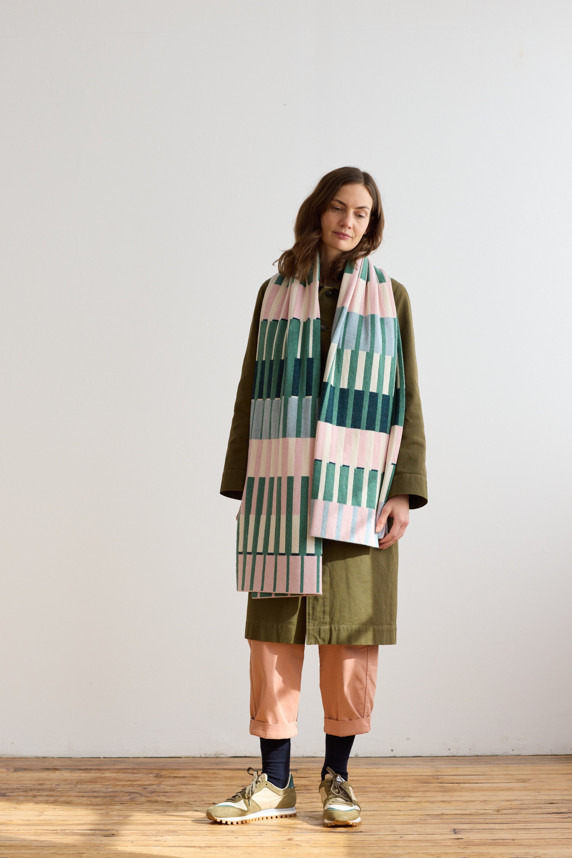 Woven rectangular scarf with pink, green, and blue vertical stripes.