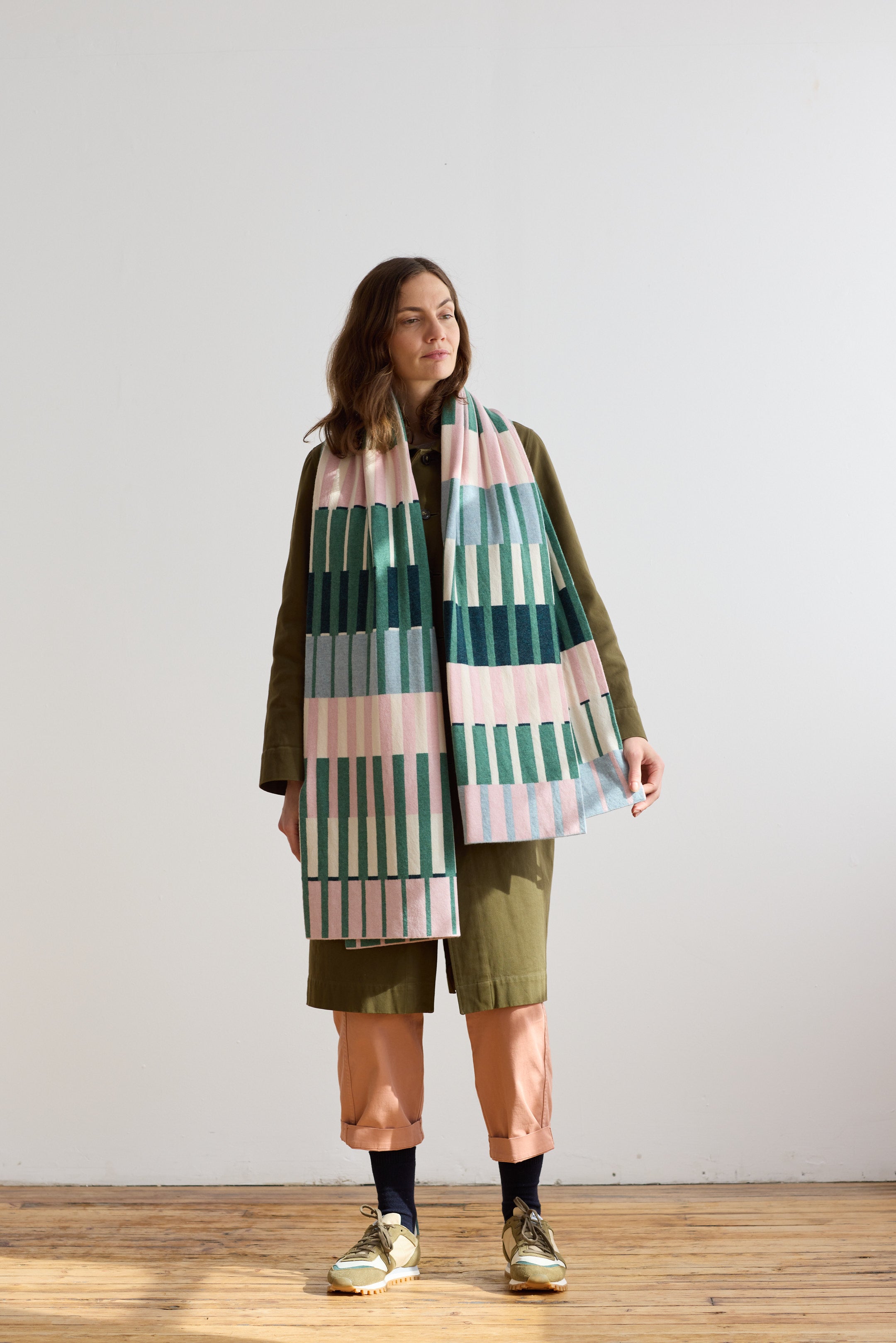 Woven rectangular scarf in pink, green, and blue stripes.
