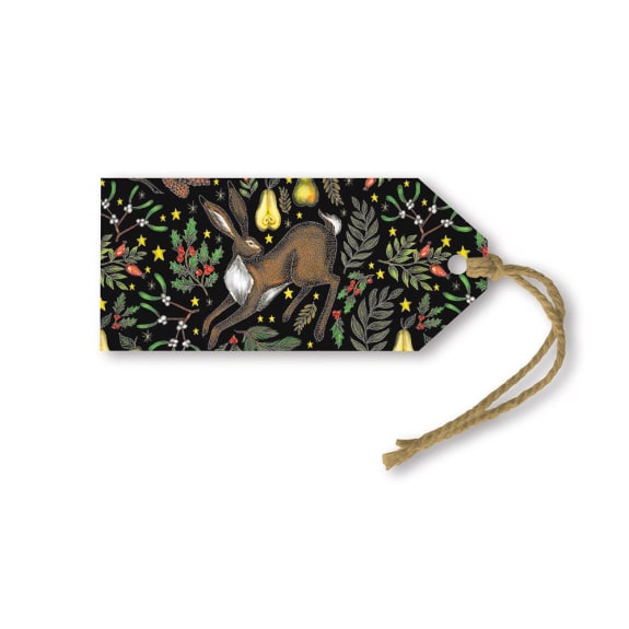 Black gift tag featuring a repeating pattern of a brown hare leaping amidst holly, mistletoe, pears, and stars.