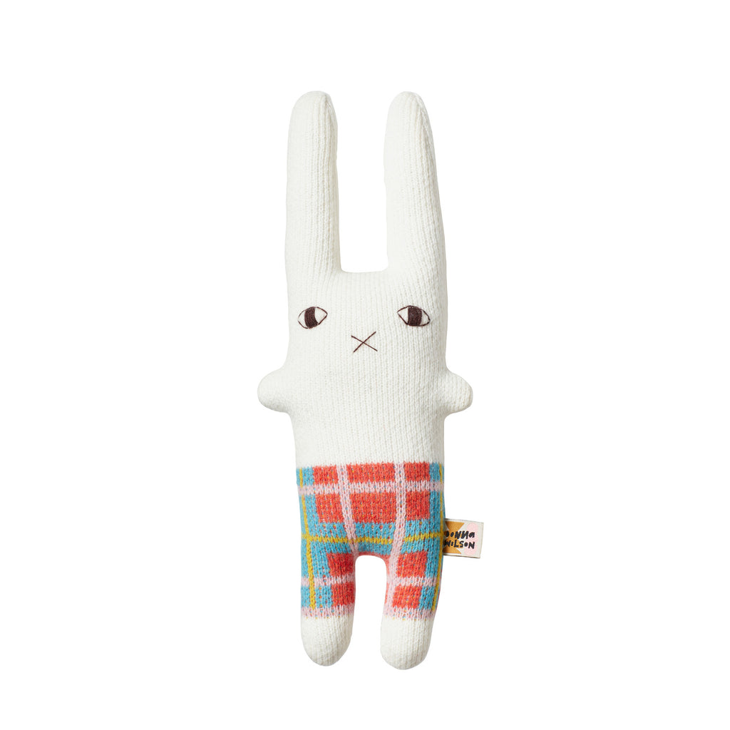 White rabbit toy with plaid orange, blue, and green pants. Brand: Donna Wilson.