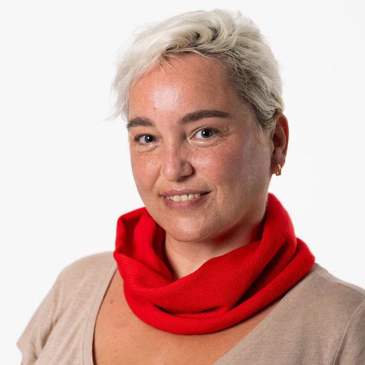 Close-up of a woman wearing a bright red ribbed neck warmer.
