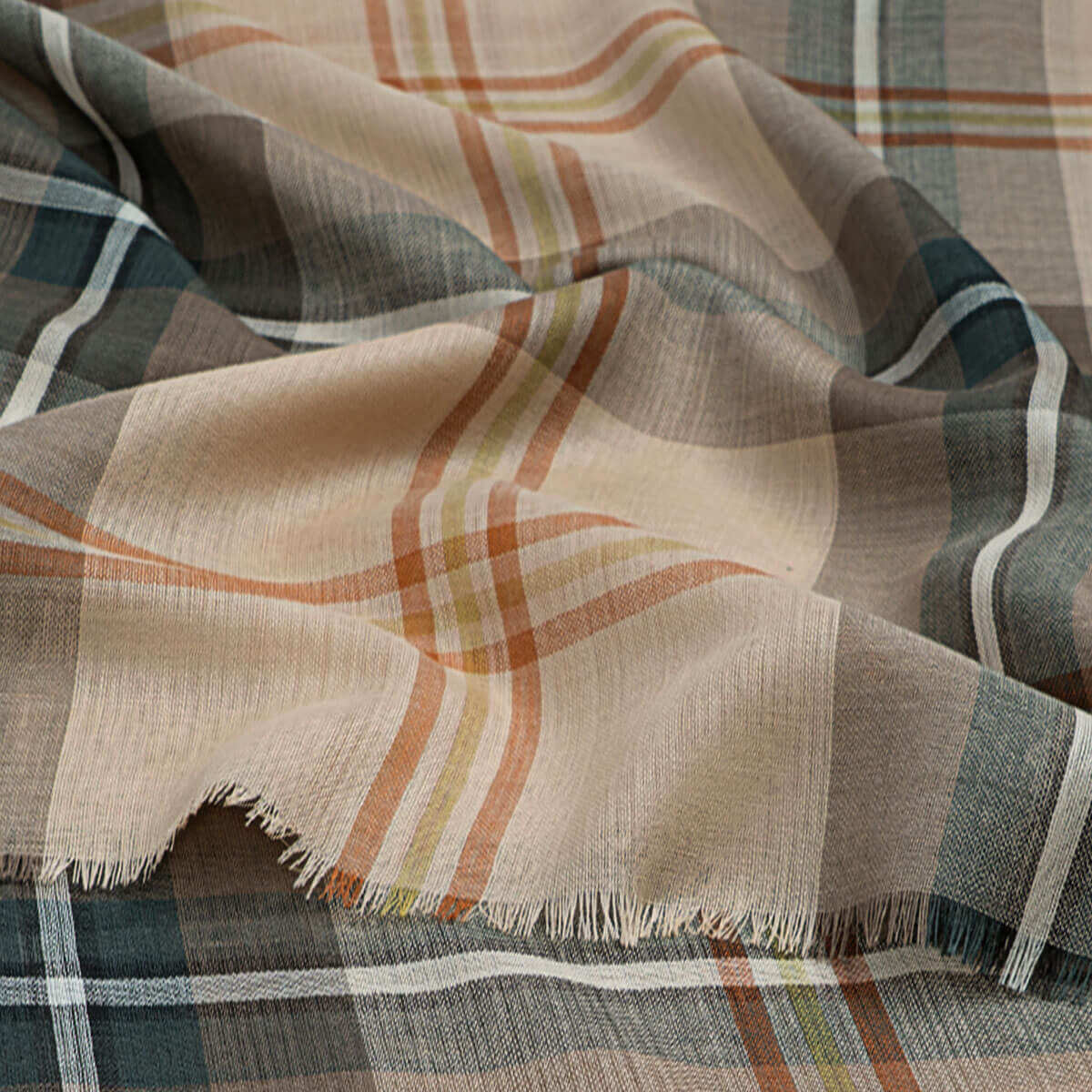 Plaid fabric with a mix of colours including beige, brown, and green.