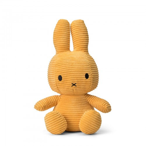 Mustard yellow corduroy Miffy plush toy, sitting.  Simple facial features.