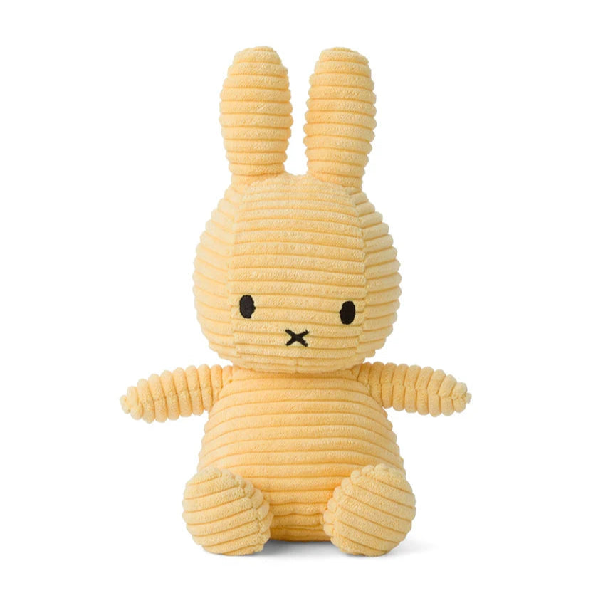 Pale yellow corduroy bunny plush toy sitting down.