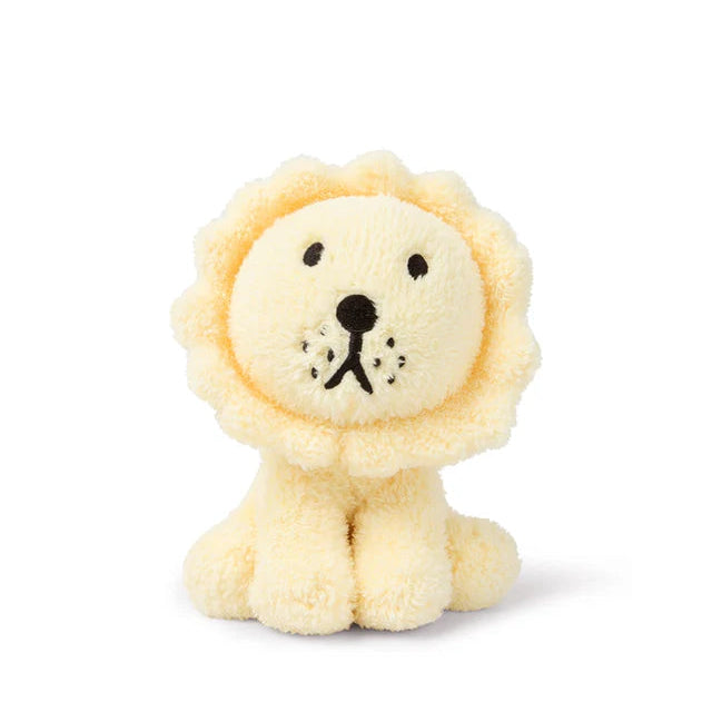 Pale yellow plush lion toy with black embroidered features.  Soft, textured fur.