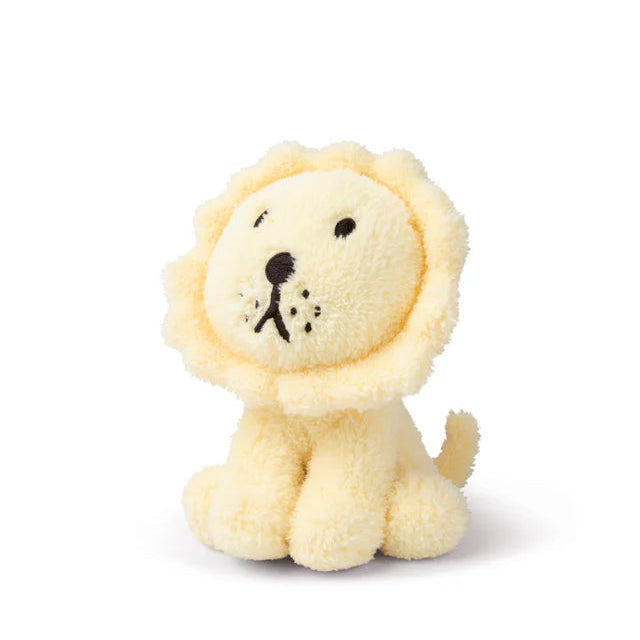Pale yellow plush lion toy with dark embroidered facial features.