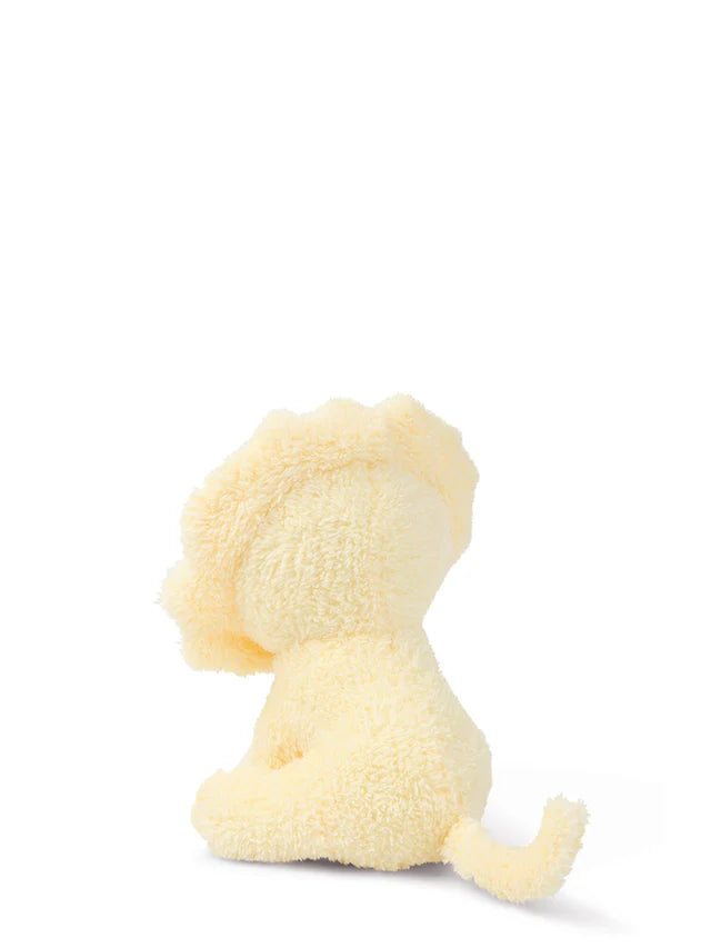 Pale yellow plush lion toy sitting, viewed from behind.  Soft, textured fur.