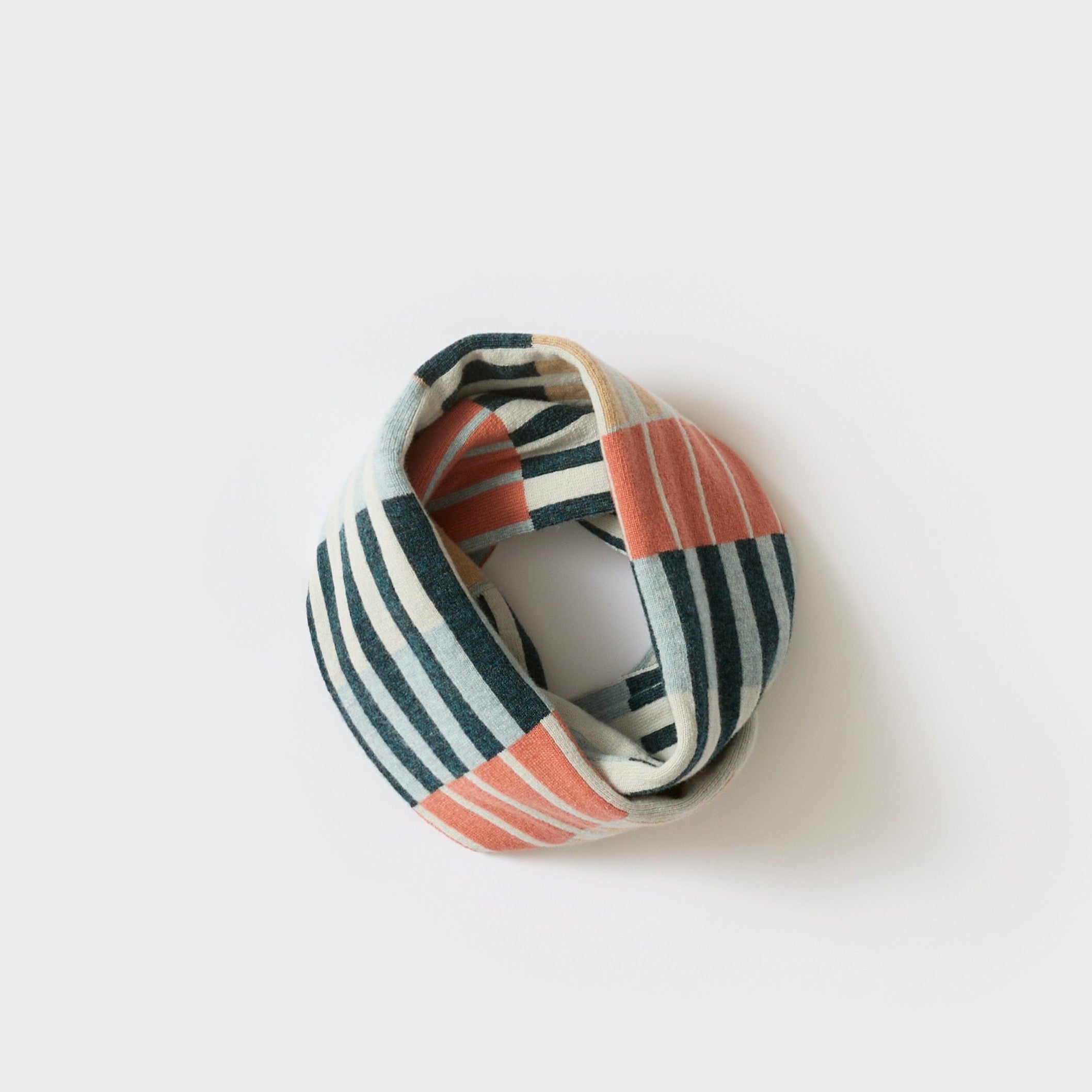 Striped and patterned knit infinity scarf in teal, coral, and cream.