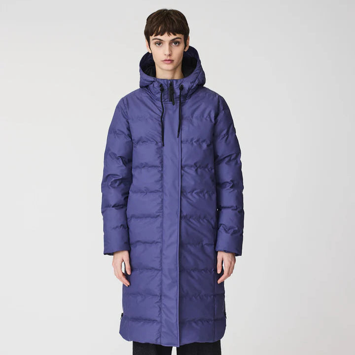 Person wearing a long blue puffer coat on a white background