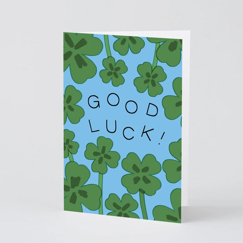 Greeting card with green clover pattern and 'Good Luck!' text on a blue background