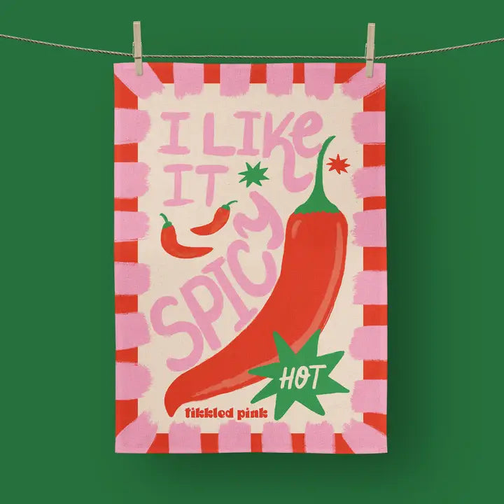 Tea towel featuring a large red chili pepper and the text "I like it spicy," accented with pink and green.