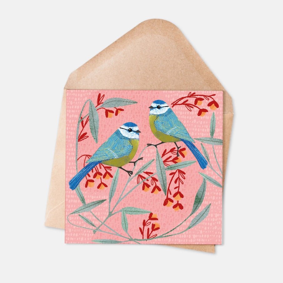 Pink greeting card featuring two blue tits perched on a flowering branch.
