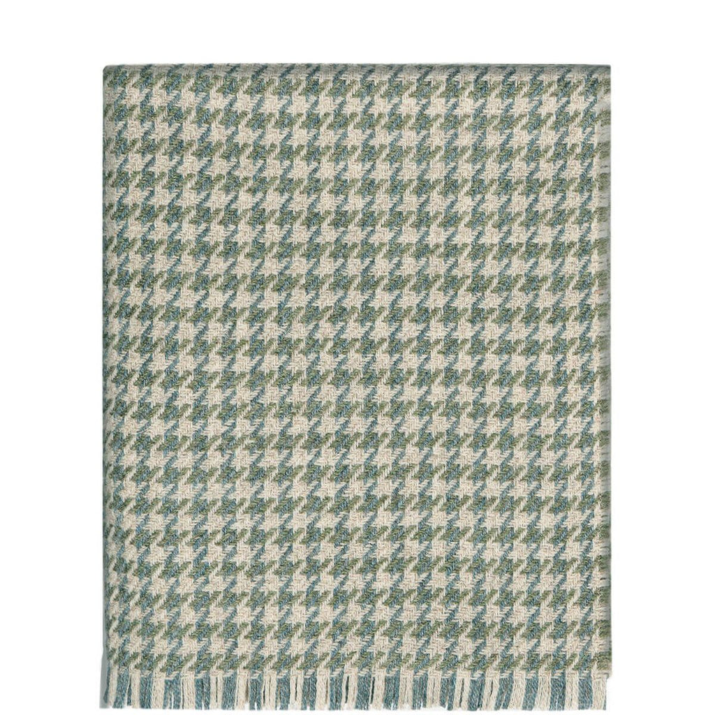 Woven throw blanket in a green and beige houndstooth pattern with fringed edges.