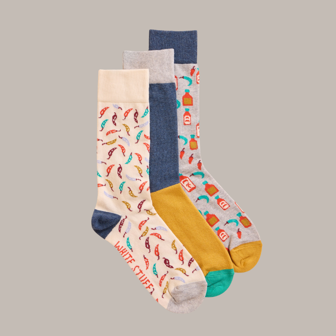 Three pairs of crew socks with colorful chili pepper and hot sauce patterns.