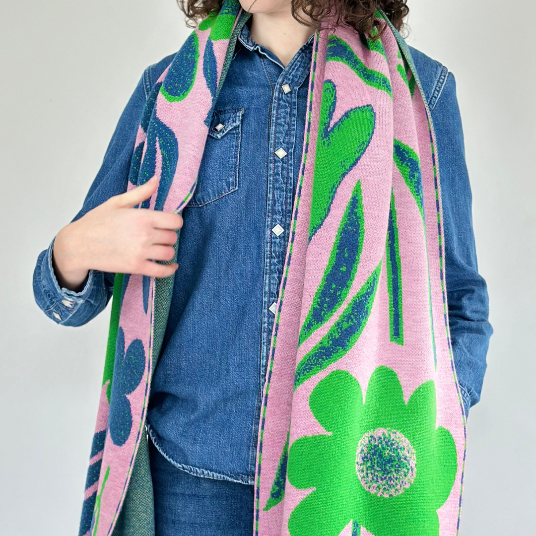 Pink and green floral knit scarf with bold, stylized flowers and leaves.