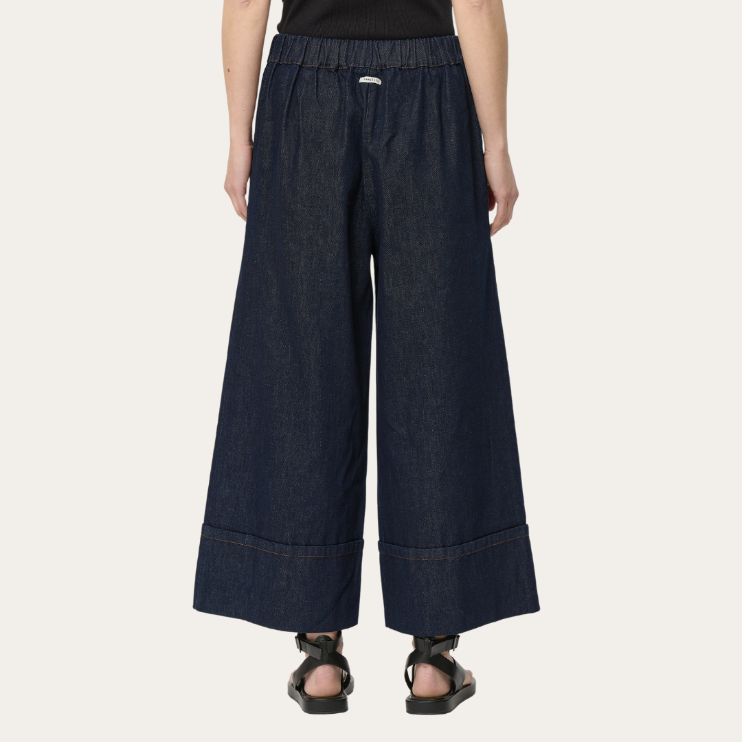 Dark wash denim wide-leg pants with an elastic waistband and cuffed hems.