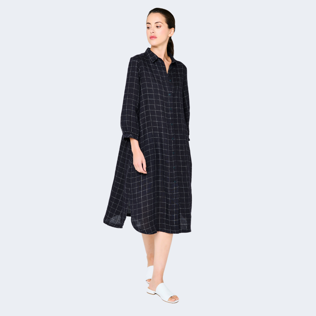 Navy blue midi shirt dress with a white grid pattern, collared neckline, and three-quarter sleeves.
