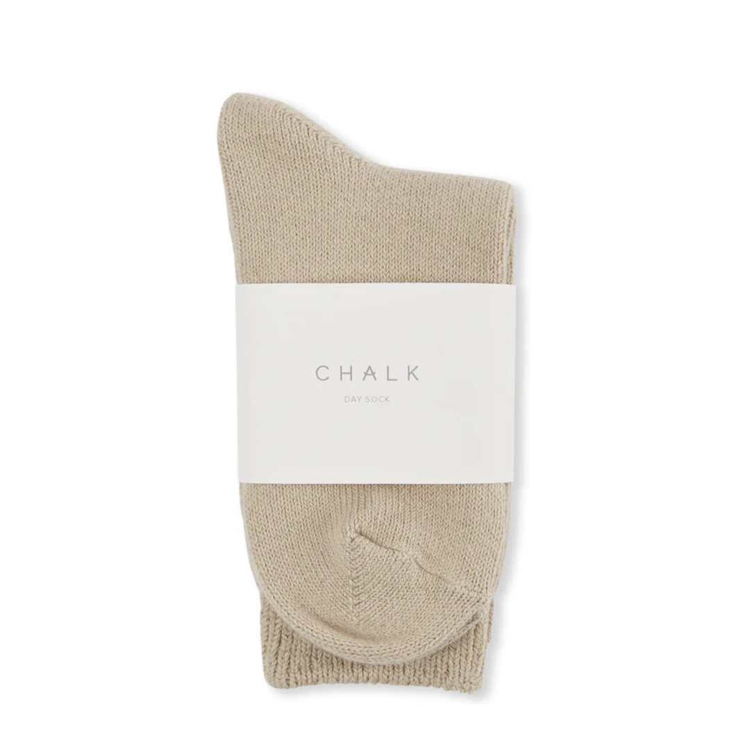Pair of beige Chalk Day Socks folded and banded with white label.