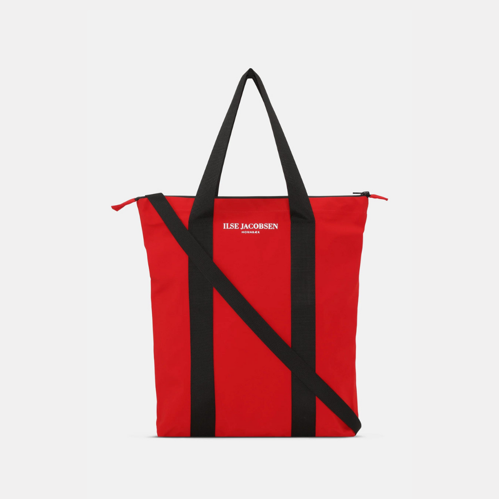 Red Ilse Jacobsen Hornbæk tote bag with black straps and shoulder strap; white logo.