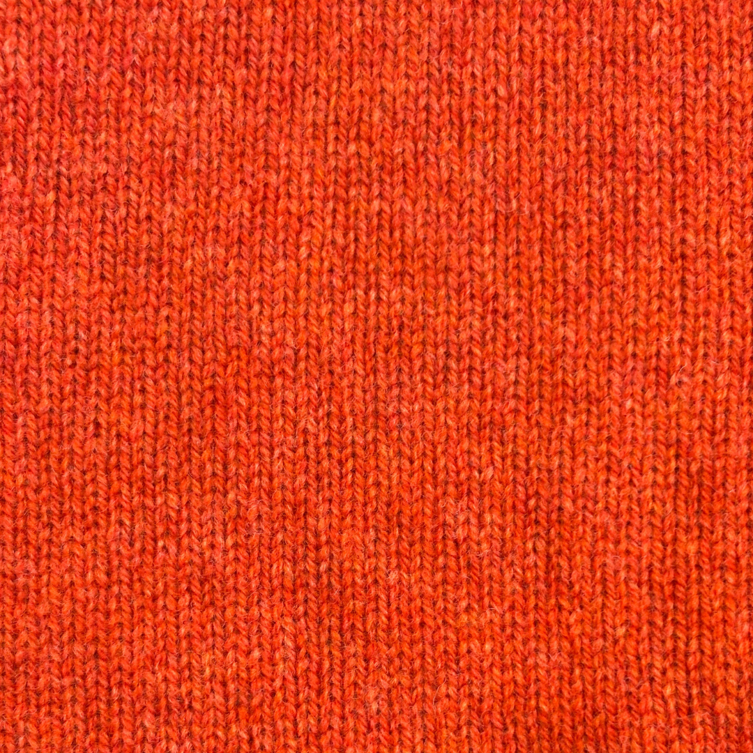 Close-up of a textured, orange knit fabric.