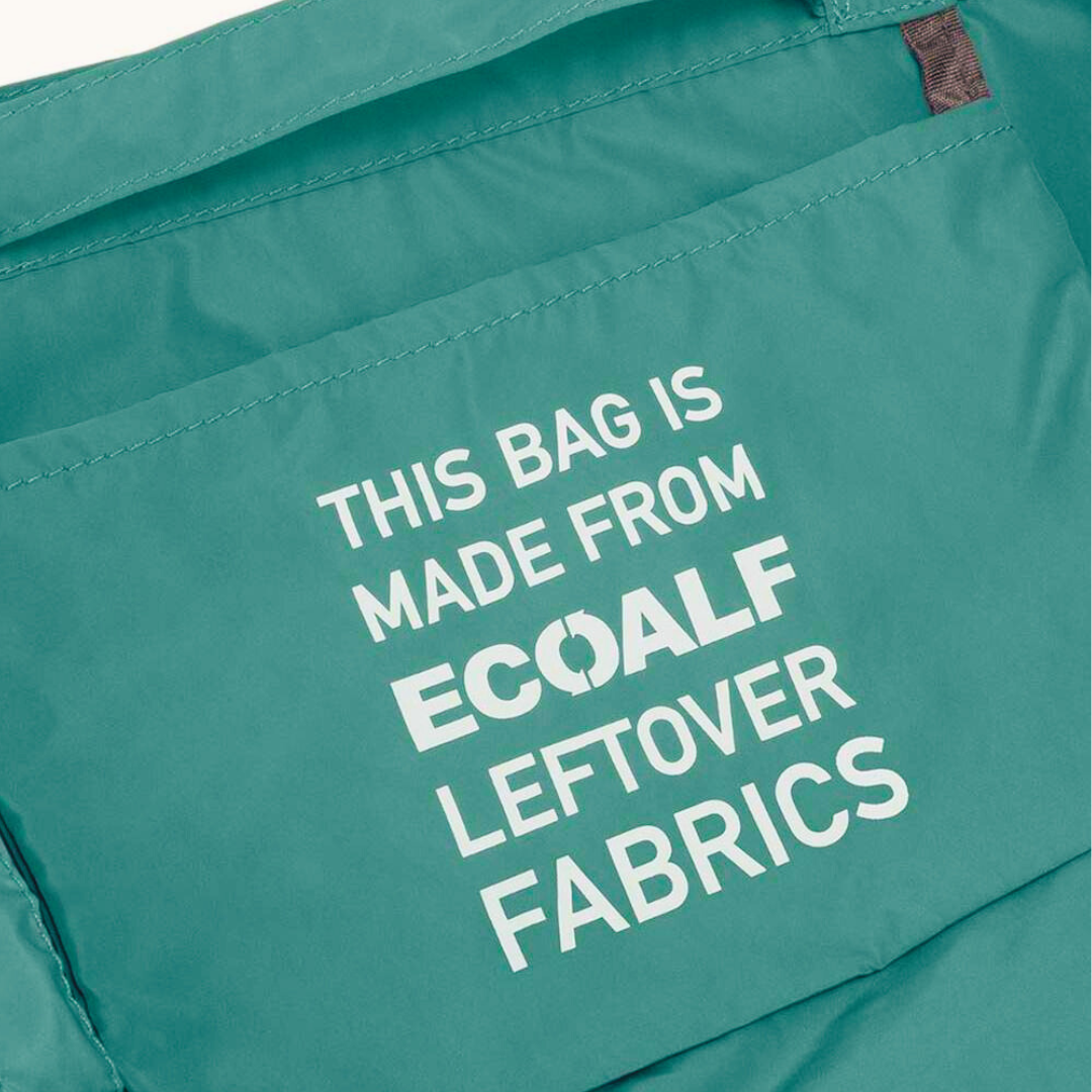 Teal Ecoalf tote bag with a pocket displaying the text: "This bag is made from ECOALF leftover fabrics."