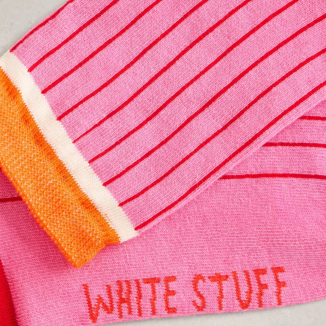 Close-up of pink fabric with red stripes and 'White Stuff' branding.